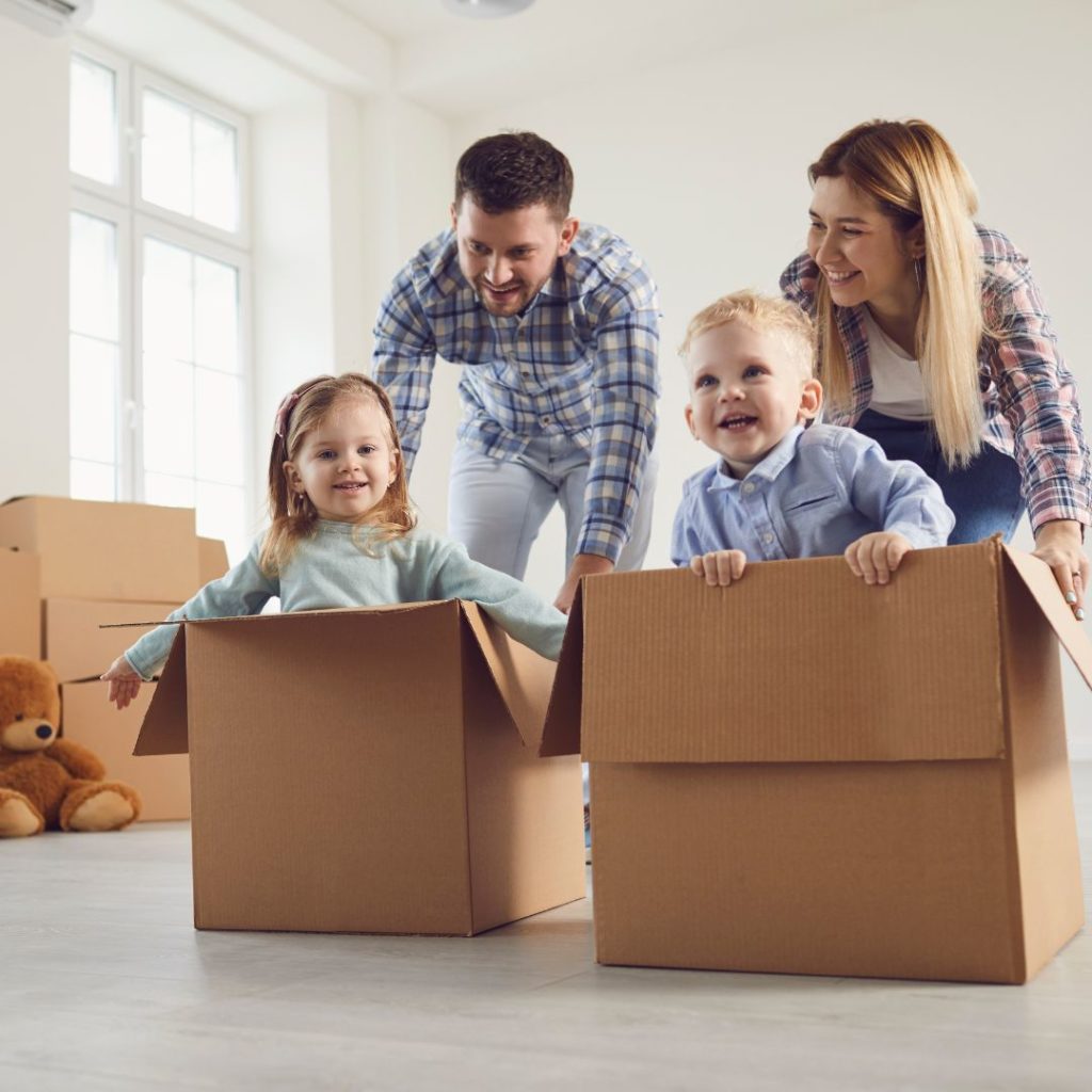 Couple de parent avec leurs enfants dans des cartons